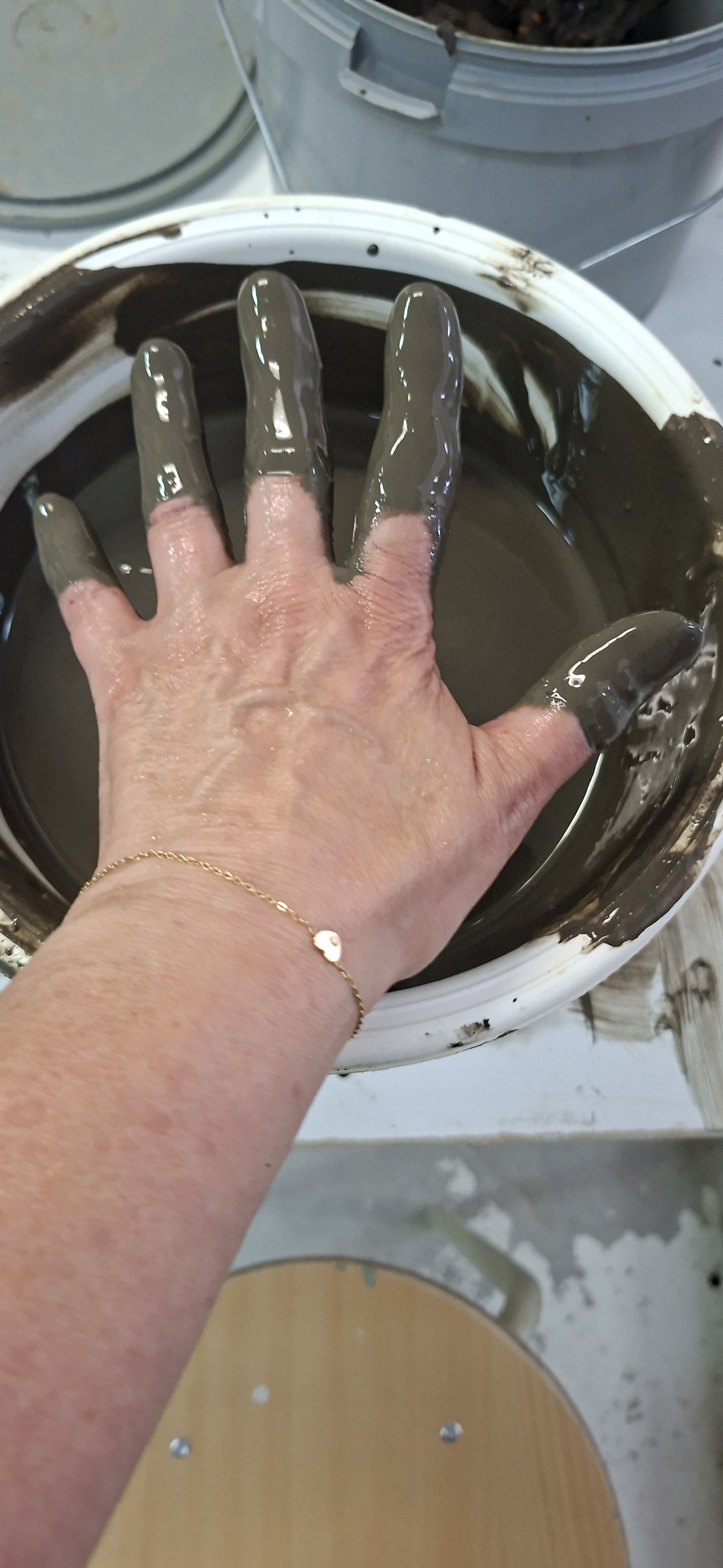 Hand strijkt de wand van een keramische schaal glad tijdens een dagdeel in het open atelier