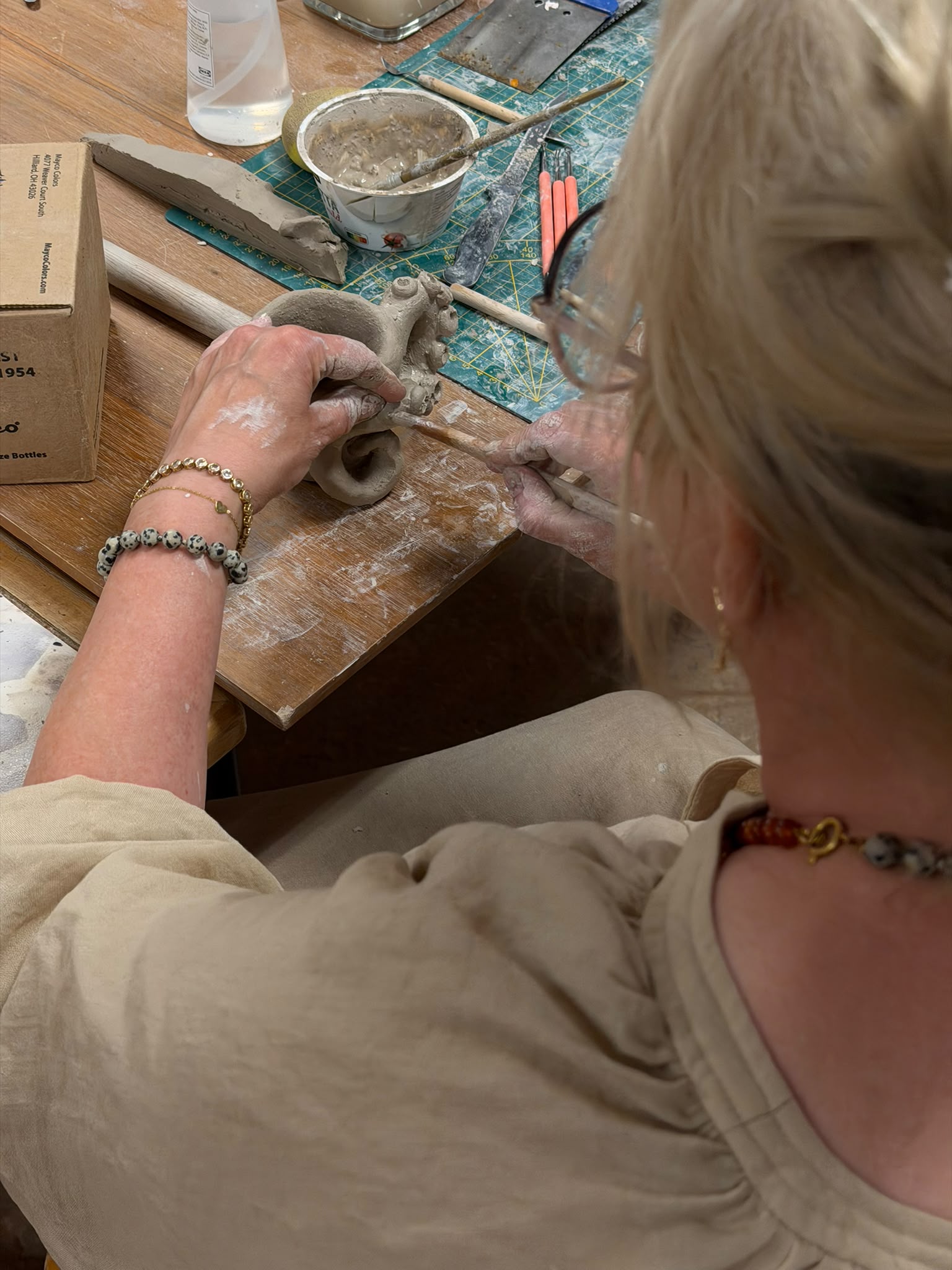 Handen vormen klei aan de werktafel in het keramiek atelier in Nijmegen